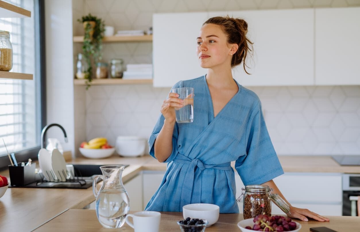 Young woman preparing muesli for breakfast in her kitchen, morning routine and healthy lifestyle.